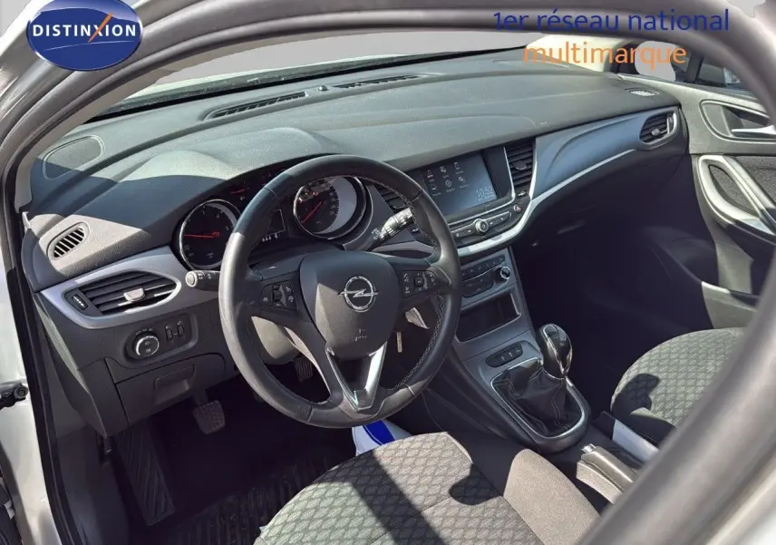 Vue intérieure côté conducteur de l'Opel Astra Sports Tourer 2021 avec tableau de bord moderne et volant multifonction.