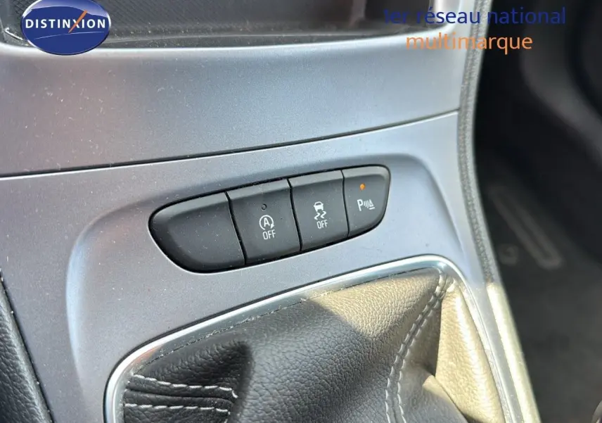 Gros plan sur la console centrale de l'Opel Astra Sports Tourer gris minéral, montrant les boutons de contrôle et le soufflet de levier de vitesse.