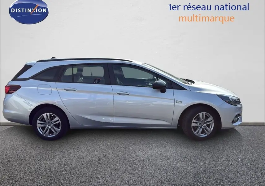 Opel Astra Sports Tourer gris minéral métal vue de profil côté gauche sur fond neutre, mettant en valeur ses lignes fluides.