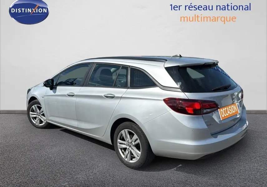 Opel Astra Sports Tourer gris minéral métal vue 3/4 arrière côté droit avec feux arrière LED et jantes alliage.