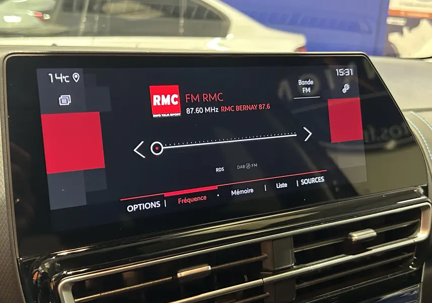 Écran tactile central du tableau de bord du Citroën C5 Aircross gris platinium, affichant la radio FM RMC à 87,6 MHz.