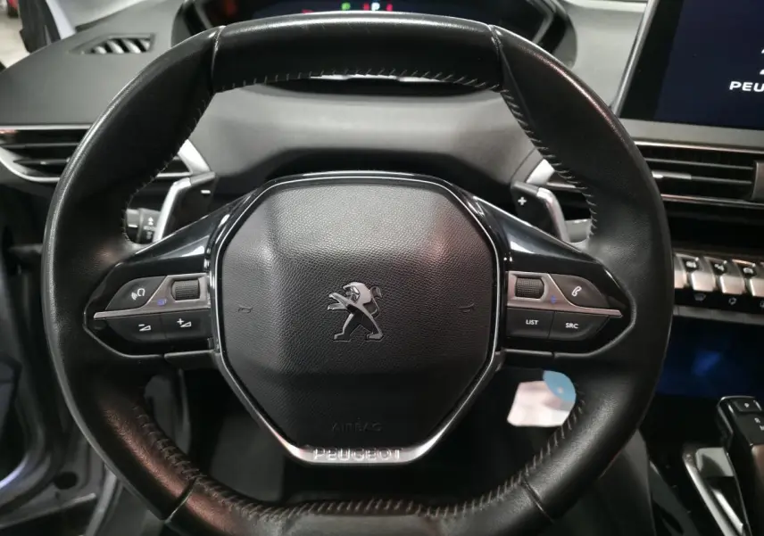 Volant en cuir noir de Peugeot 5008 2020 avec commandes intégrées, tableau de bord et écran tactile visibles en arrière-plan.