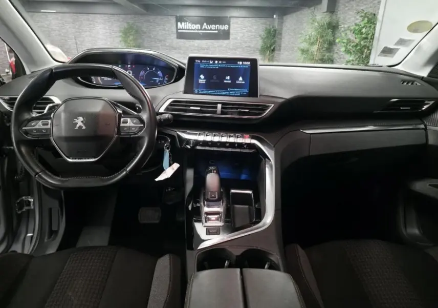 Intérieur Peugeot 5008 2020 vu de face, volant compact cuir, écran tactile 8 pouces et console centrale moderne noire.