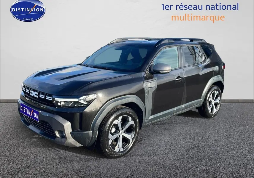 SUV Dacia Duster noir en 3/4 avant droit, avec jantes alu et barres de toit visibles.