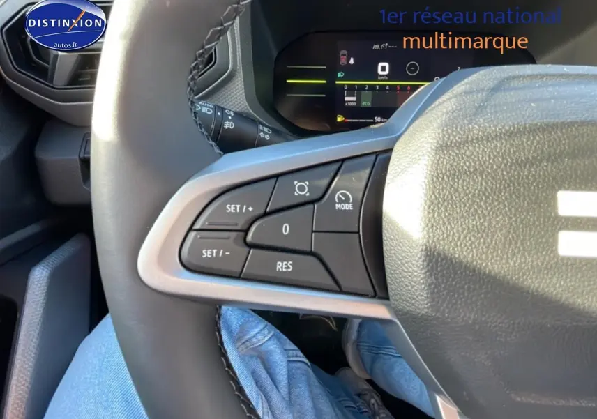 Gros plan sur le volant multifonction noir du Dacia Duster 2026, avec commandes de régulateur de vitesse visibles.