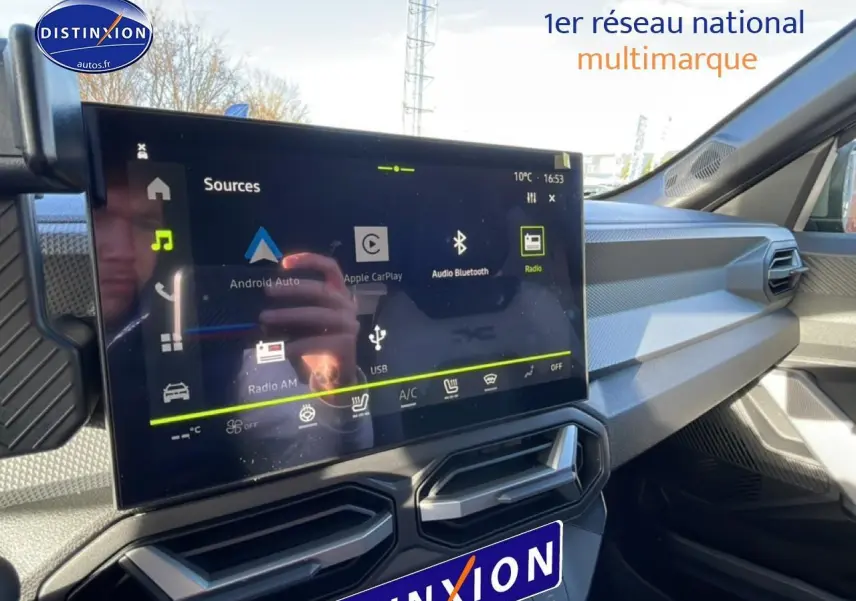 Vue intérieure du tableau de bord du Dacia Duster 2026 noir, avec écran tactile central et aérateurs angulaires.