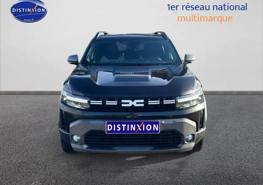Vue frontale du Dacia Duster noir 2026 avec calandre distinctive et phares LED allumés.