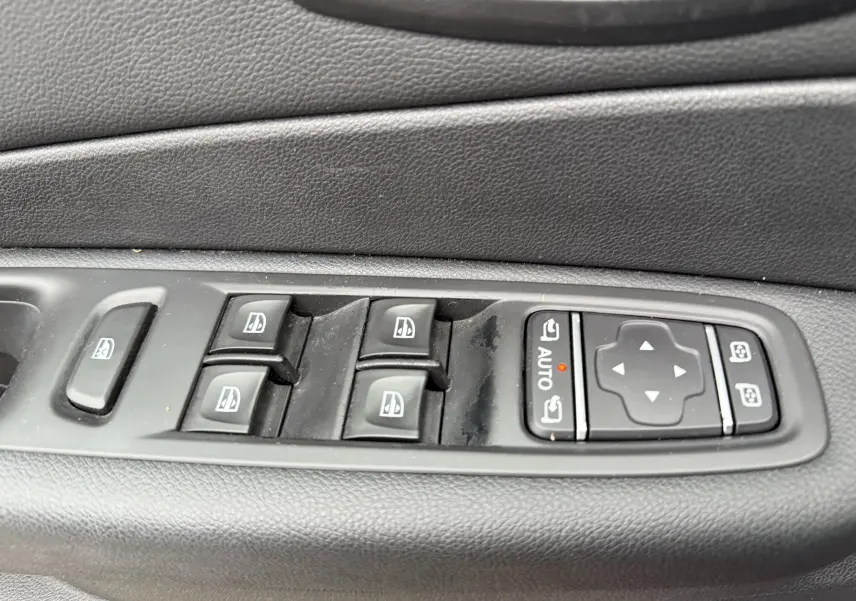 Panneau de commandes des vitres électriques et réglages des rétroviseurs côté conducteur d’un Renault Captur rouge 2017.