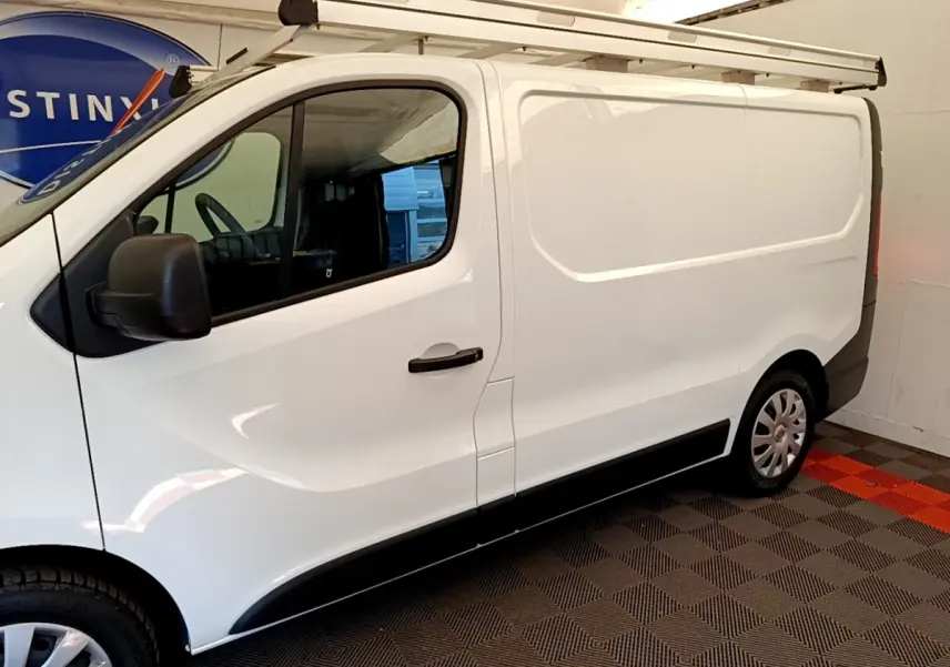 Vue de profil côté gauche du fourgon blanc Renault Trafic L1H1 1200 Confort 2021 avec galerie de toit.