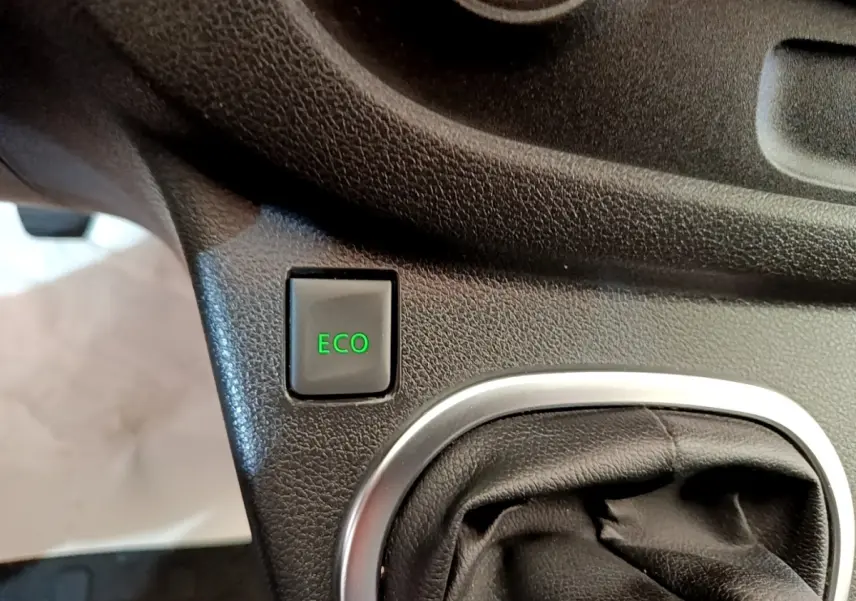 Gros plan sur le bouton ECO vert et le soufflet de levier de vitesse noir dans l’habitacle du Renault Trafic blanc.
