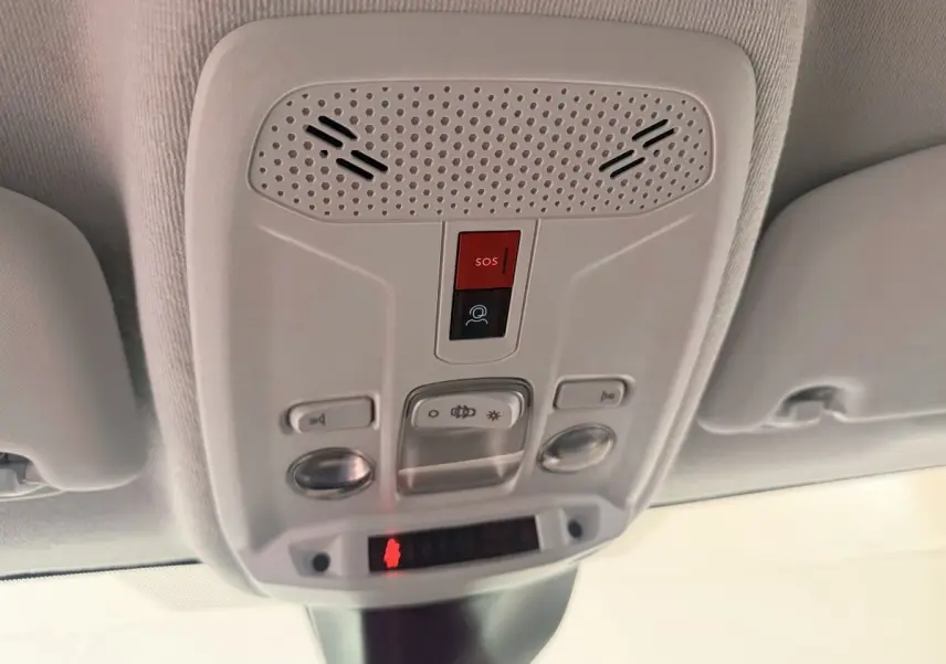 Plafonnier intérieur blanc avec boutons SOS et éclairage, vue en contre-plongée dans une Peugeot 208 blanche.