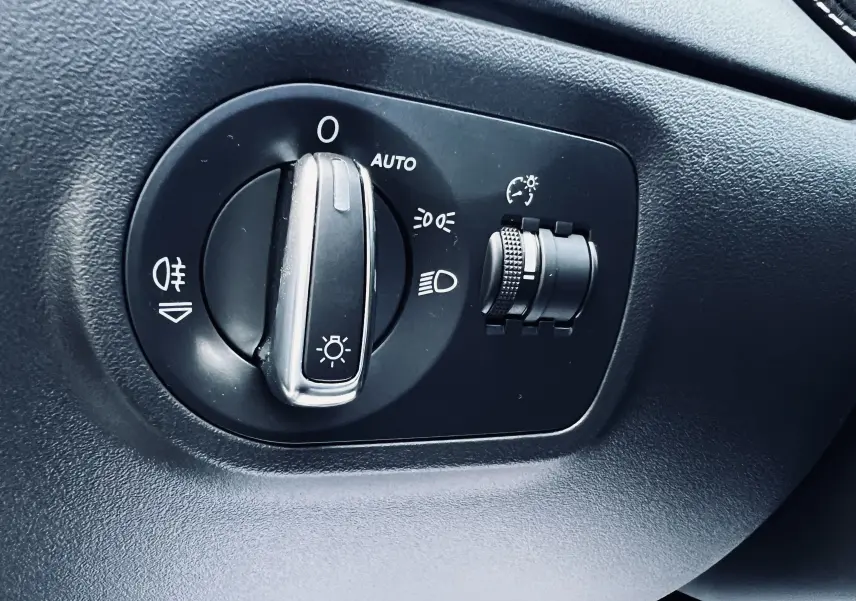 Gros plan sur le bouton de commande des phares et réglage de l'éclairage intérieur d'une Audi TT RS Roadster blanc.