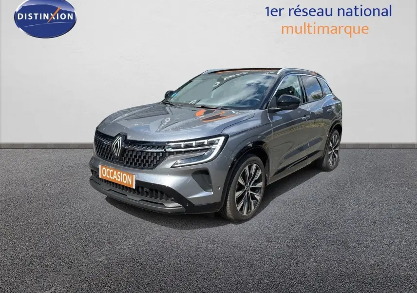 Renault Austral gris schiste métal en 3/4 avant droit, mettant en valeur ses phares LED et sa calandre distinctive.