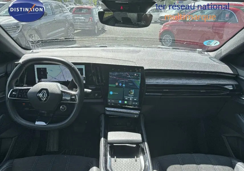 Intérieur du Renault Austral 2024 montrant le tableau de bord moderne avec écran tactile vertical et volant multifonction noir.