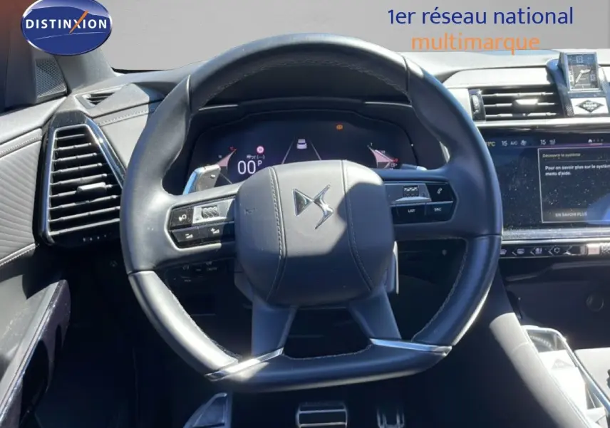 Vue rapprochée du volant cuir noir du DS7 2024, avec tableau de bord numérique et écran tactile visible à droite.