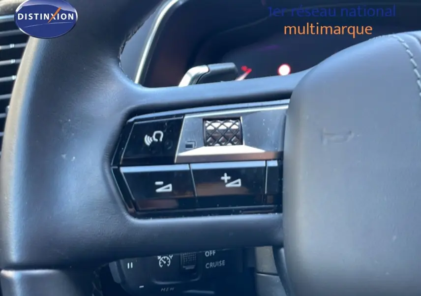 Gros plan sur le volant noir du DS7 2024, mettant en valeur les commandes intégrées côté gauche.