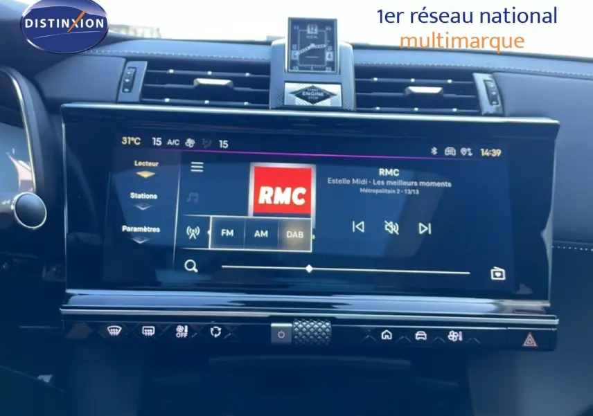 Vue rapprochée de l’écran tactile central du DS7 2024 noir métal, affichant la radio RMC et commandes climatiques.