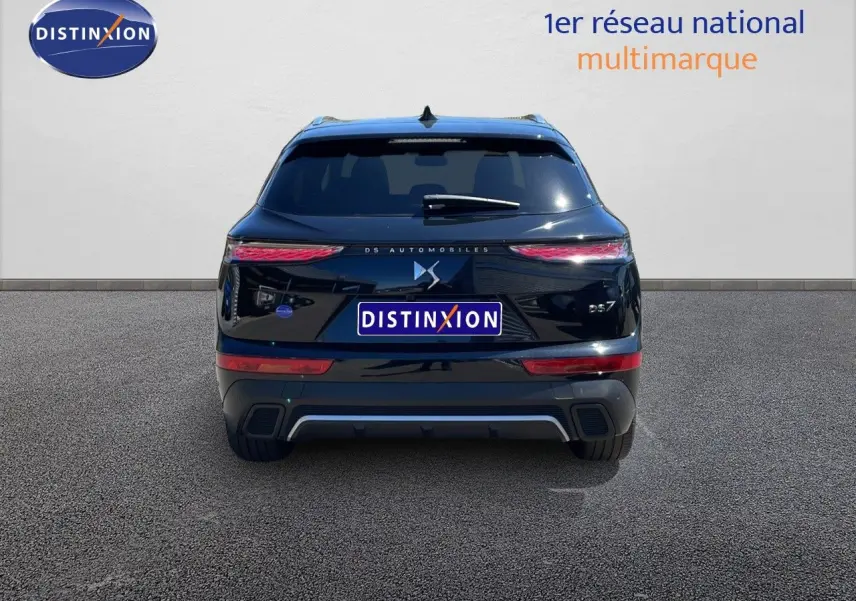 Vue arrière d'un DS7 noir métal 2024 avec feux LED effilés et logo DS centré sur un fond clair.
