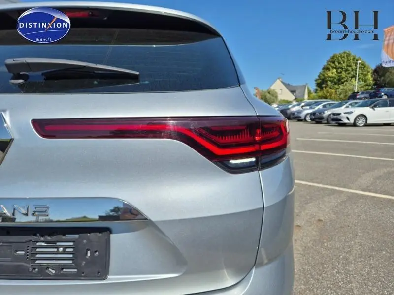 Vue arrière droite du break Renault Mégane 2024 gris Titanium avec feux arrière LED distinctifs et lunette arrière.