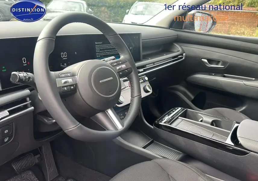 Intérieur du Hyundai Tucson 2025 vu côté conducteur, tableau de bord moderne avec écran tactile et volant cuir noir.