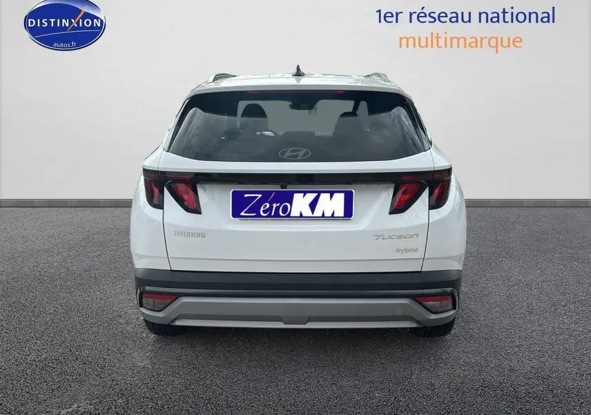 Vue arrière d'un Hyundai Tucson blanc Sérénité 2025 avec feux arrière LED et logo Hyundai visible.