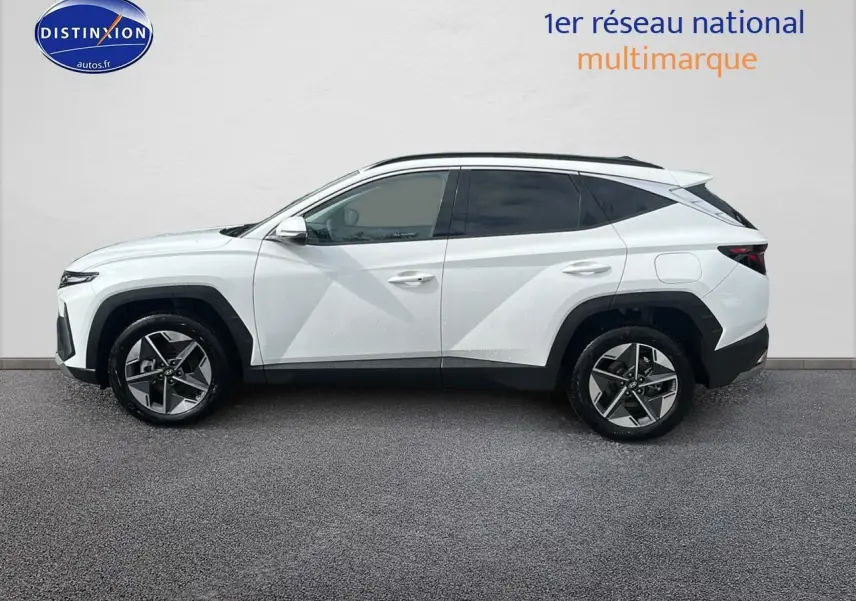 Profil côté gauche du Hyundai Tucson blanc sérénité 2025 avec jantes alliage et vitres teintées.