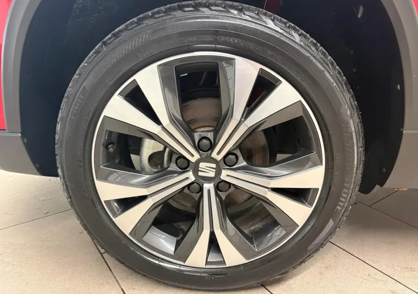 Gros plan sur la roue avant droite avec jante alliage bicolore du SEAT Ateca Rouge Velvet 2024.