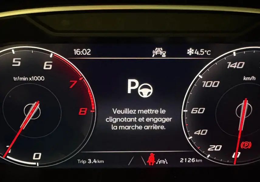 Tableau de bord numérique du SEAT Ateca 2024 affichant un message d'alerte au stationnement, avec compte-tours et compteur de vitesse.