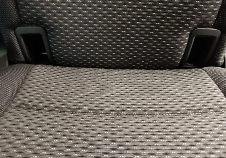 Gros plan sur l'assise en tissu gris foncé d'un siège arrière individuel du Volkswagen Touran 2024.