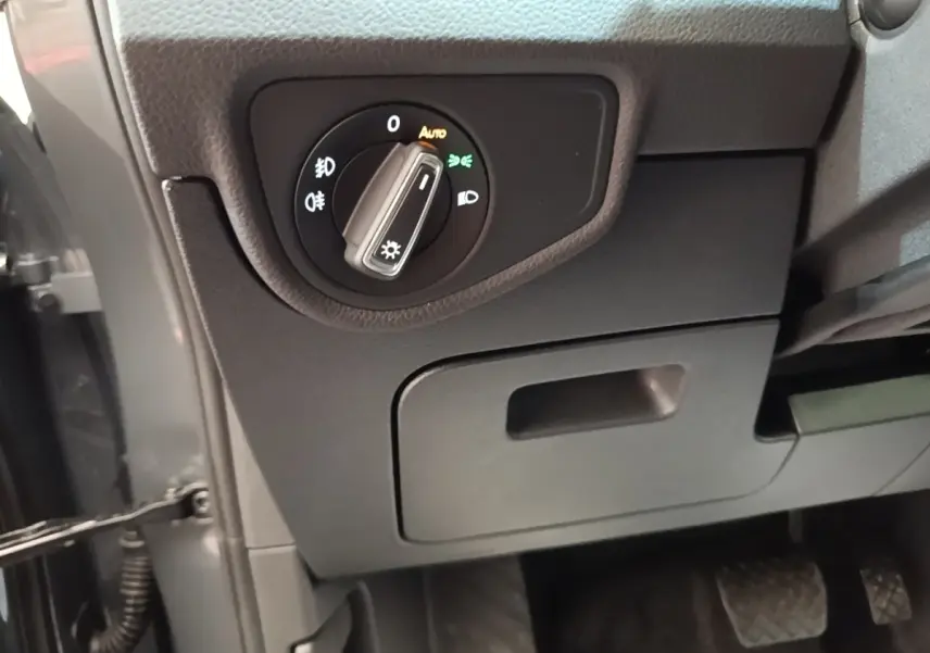 Détail intérieur du tableau de bord côté conducteur du Volkswagen Touran 2024 avec commande des phares.