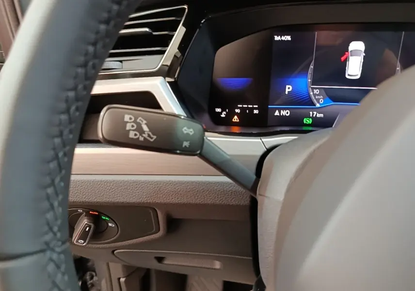 Gros plan sur le combiné d'instruments digital du Volkswagen Touran 2024 avec affichage multifonctions et commandes au volant.
