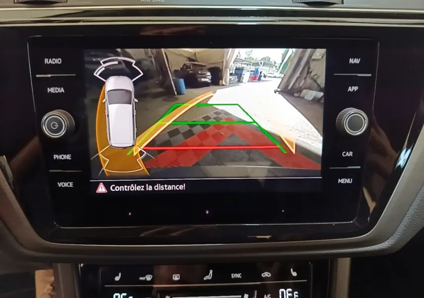 Écran tactile central affichant la caméra de recul avec guidage, dans un Volkswagen Touran gris clair 2024.