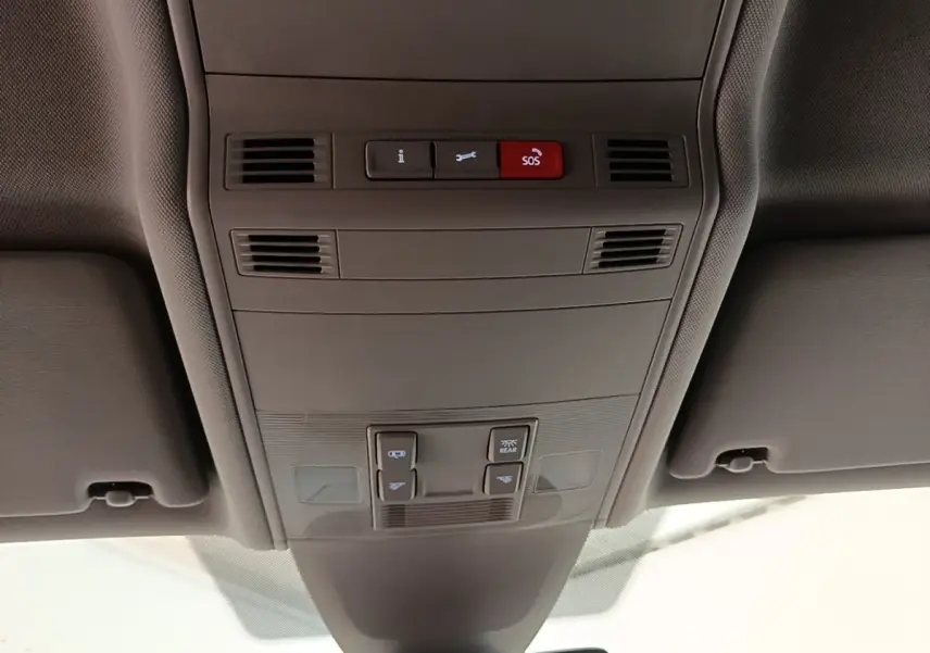 Vue intérieure du plafonnier gris clair du Volkswagen Touran 2024 avec boutons SOS et commandes d’éclairage.