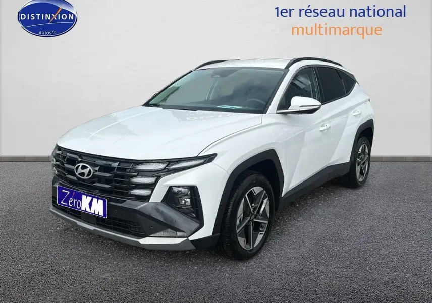 Hyundai Tucson 2025 blanc sérénité vu en 3/4 avant droit avec calandre noire et jantes alliage 18 pouces.