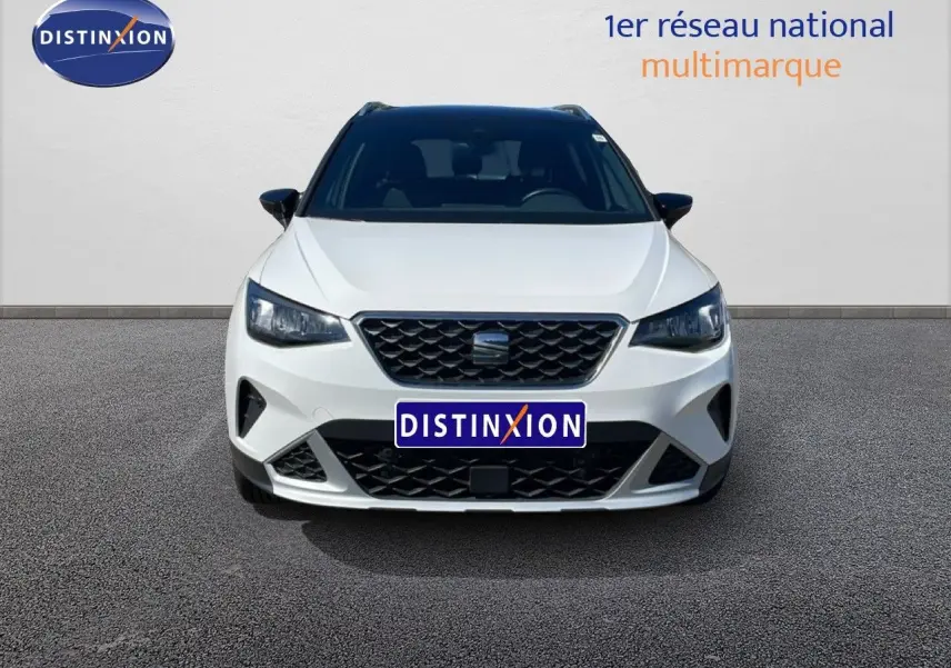 Vue frontale d’un SEAT Arona blanc avec toit noir, mettant en valeur sa calandre et ses phares LED distinctifs.
