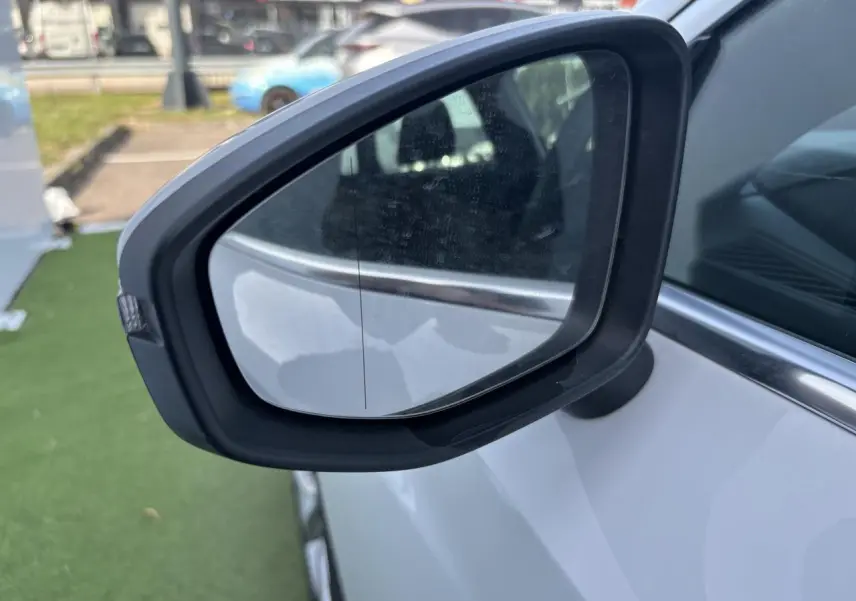 Rétroviseur droit noir sur Audi A3 Sportback blanc Arkona, vue rapprochée côté passager.