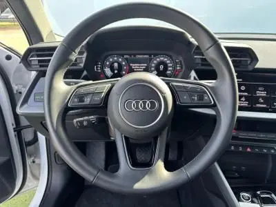 Vue centrée sur le volant cuir 3 branches de l'Audi A3 Sportback 2024 avec tableau de bord numérique et commandes intégrées