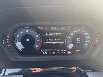 Tableau de bord numérique de l'Audi A3 Sportback 2024 affichant la consommation et la vitesse, vue frontale intérieure.