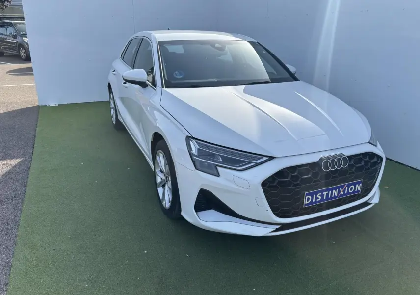 Audi A3 Sportback blanc Arkona vue 3/4 avant droit avec calandre noire hexagonale et phares LED distinctifs.