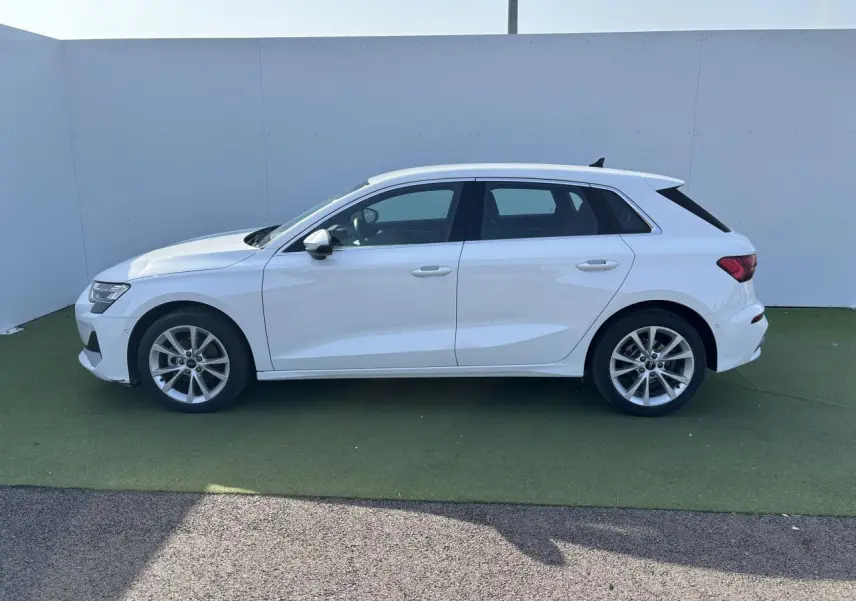 Profil côté gauche d'une Audi A3 Sportback blanche Arkona 2024 avec jantes alliage 5 branches parallèles.