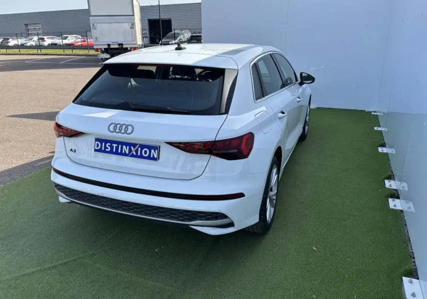 Audi A3 Sportback blanc Arkona vue 3/4 arrière droit, avec feux arrière LED et jantes alliage cinq branches.