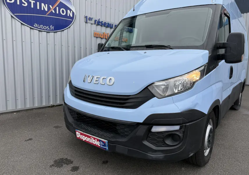 Vue 3/4 avant droit d’un Iveco Daily Fourgon bleu clair de 2017 avec calandre noire et phares allumés.