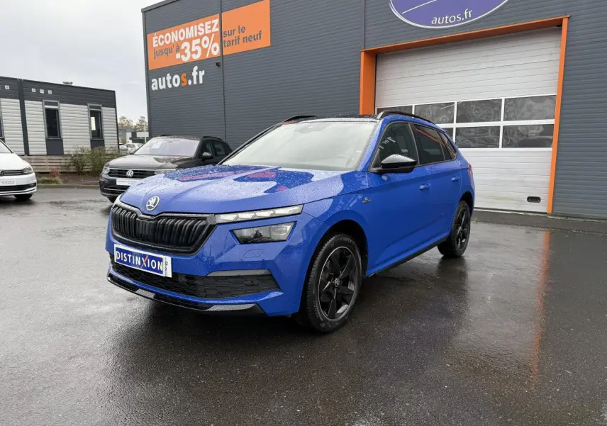 Vue 3/4 avant d'un Skoda Kamiq Monte-Carlo bleu Energy avec jantes alliage noires et calandre noire brillante.