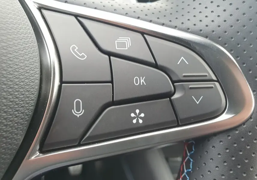 Gros plan sur les commandes multifonctions du volant perforé du Renault Captur Bleu Iron 2026.