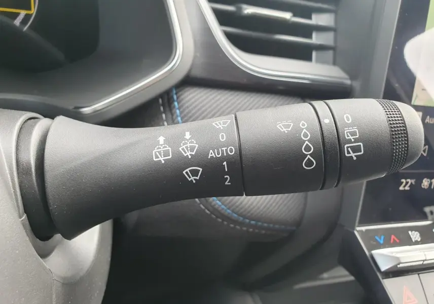 Gros plan sur la commande d’essuie-glace du Renault Captur 2026, intérieur noir avec surpiqûres bleues.