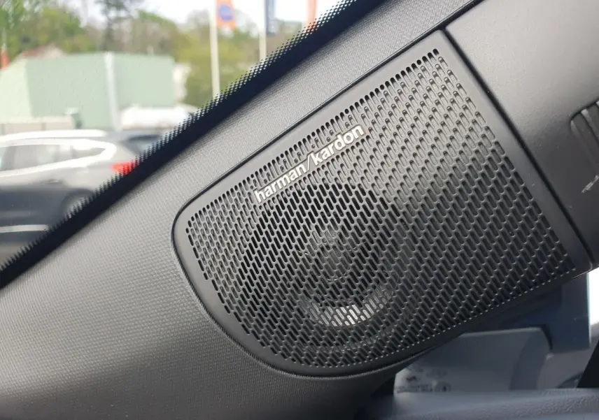 Gros plan sur l’enceinte Harman Kardon noire intégrée dans l’habitacle du Renault Captur bleu Iron.