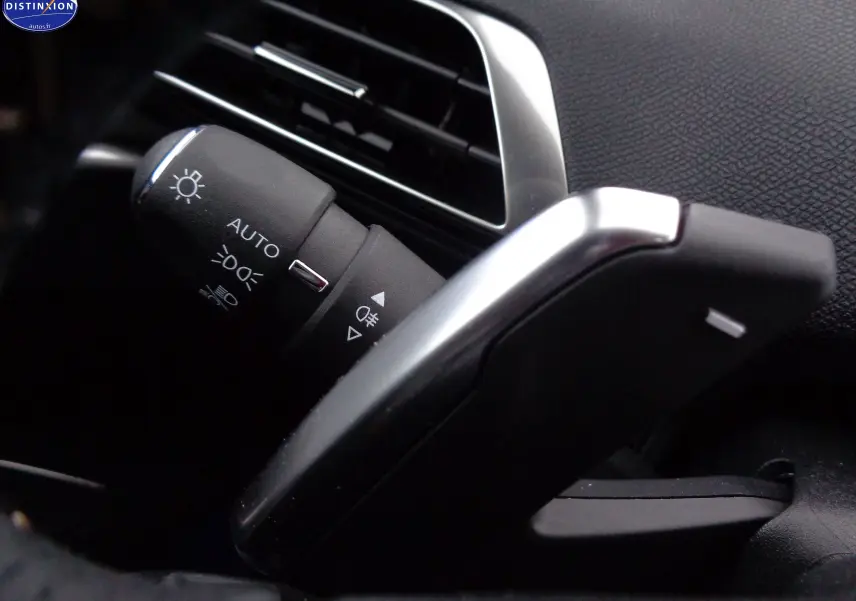 Gros plan sur la commande des phares et clignotants du Peugeot 3008 2023, intérieur noir avec détails argentés.