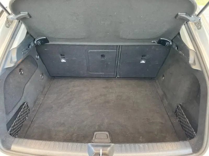 Coffre ouvert et vide du Mercedes GLA 200 Sensation gris montagne, montrant l'espace de chargement et les filets latéraux.