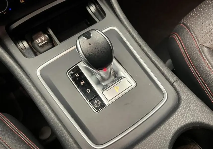 Le levier de vitesses automatique noir avec surpiqûres rouges sur l'accoudoir d'une Mercedes Classe A AMG 2015.