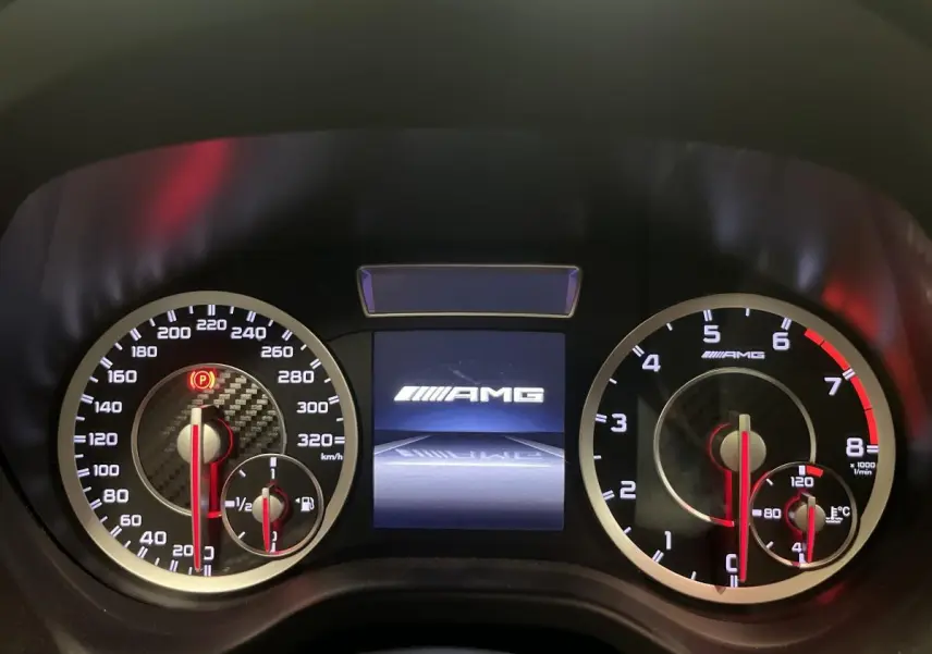 Gros plan sur le combiné d'instruments AMG avec compte-tours et vitesse, affichage central lumineux.
